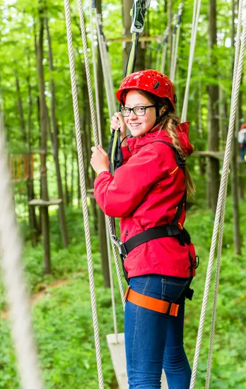 Continuous belay trolley running along the safety lifeline of a high-wire forest course